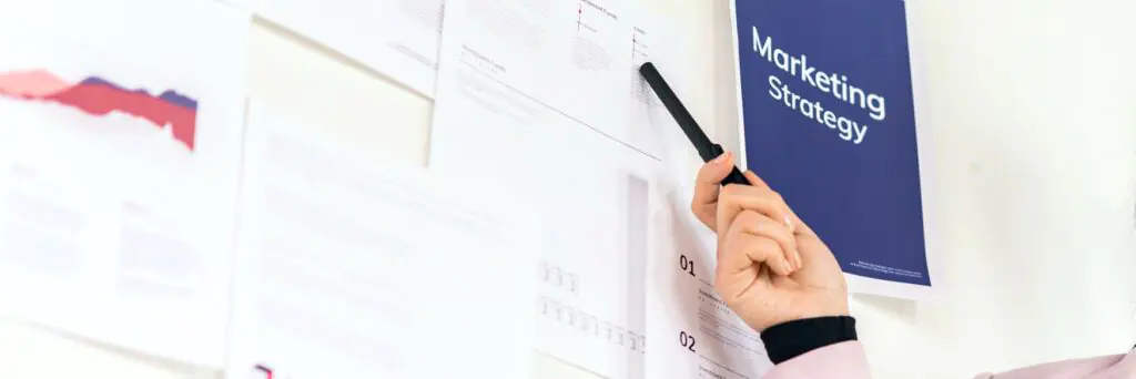 Businesswoman presenting a marketing strategy on a white wall