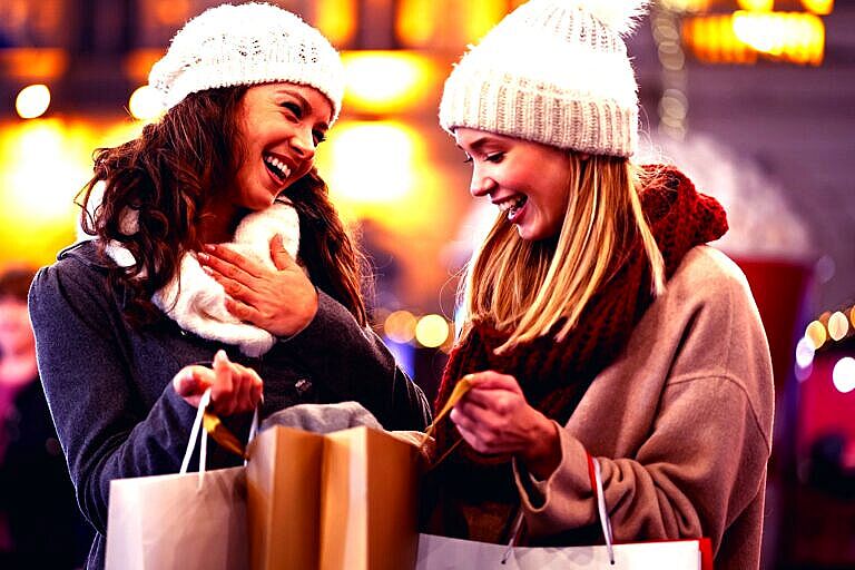 Happy women friends are shopping for presents at Christmas. People holiday sale shopping concept